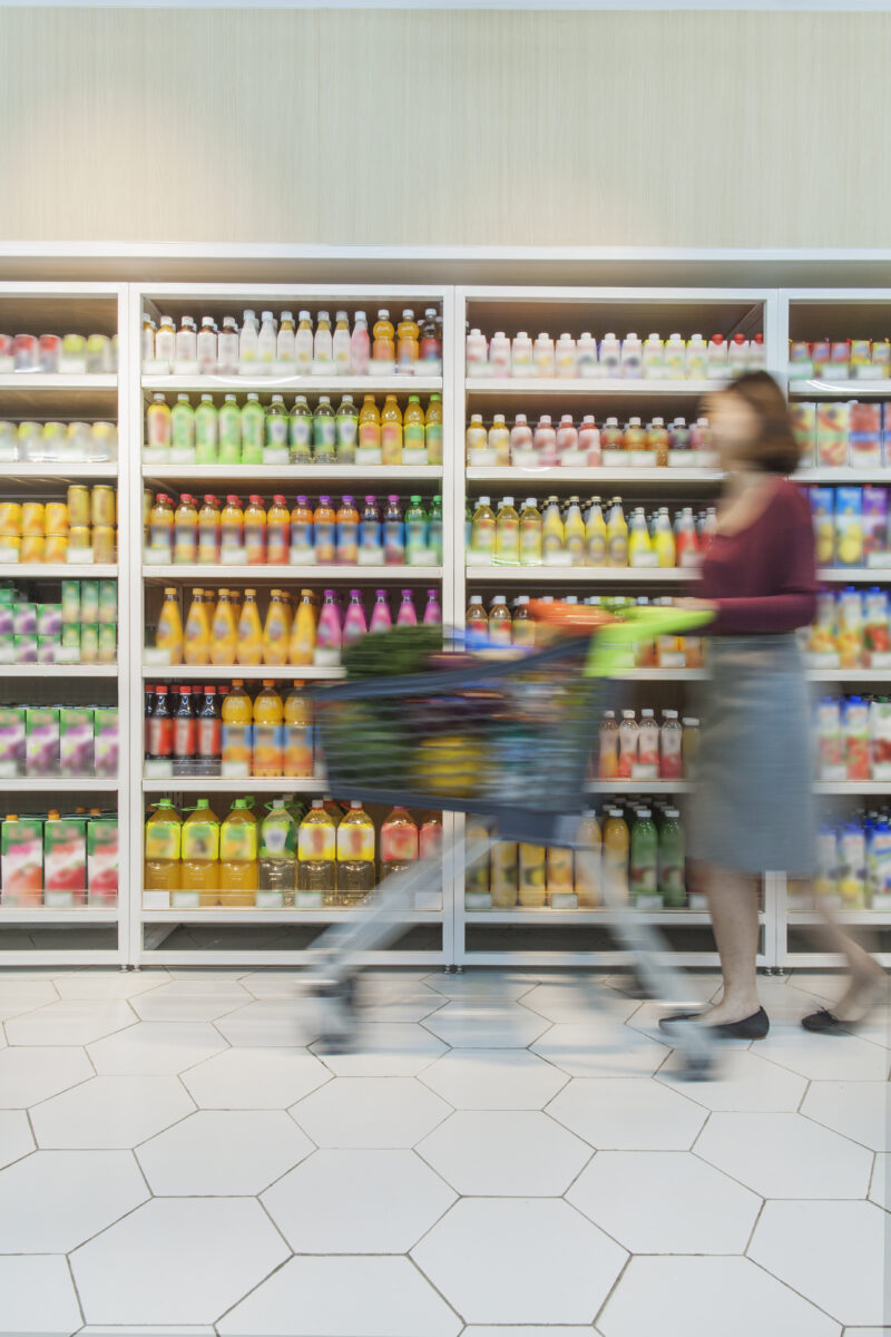 woman pushing shopping cart in supermarket